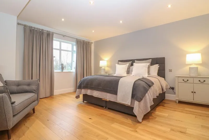 The Little Paddock master bedroom with grey styling and oak floors