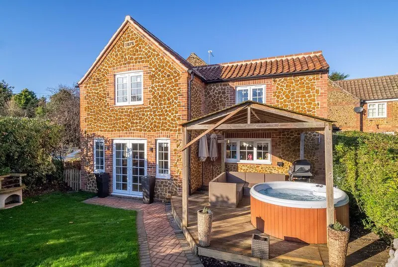 The Malthouse Dersingham rear exterior with hot tub under pergola and garden