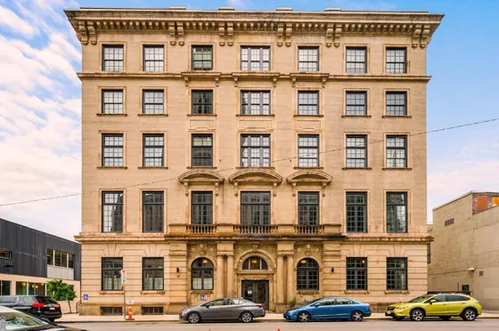 Large brick building with cars parked in front of it