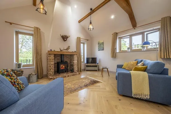 The Milking Parlour living room with wood burner and vaulted beams