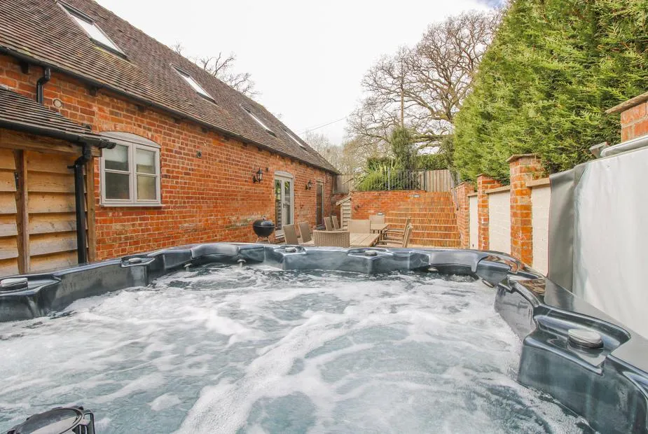The Milking Parlour hot tub beside the brick barn