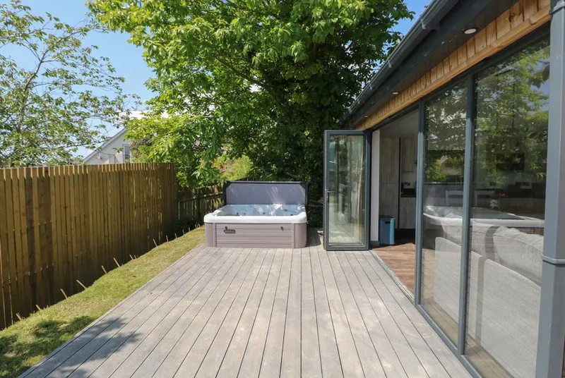 The Nest Brython hot tub on private timber deck beside glass cabin
