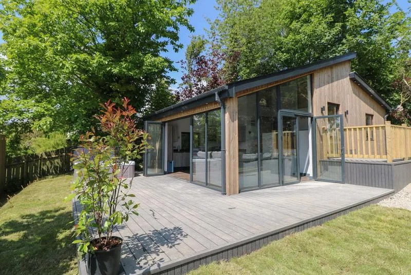 The Nest Brython modern glass and timber cabin from landscaped garden