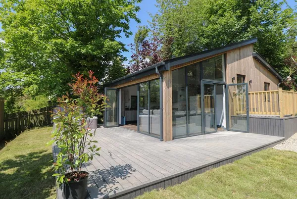 The Nest Brython modern glass and timber cabin from landscaped garden