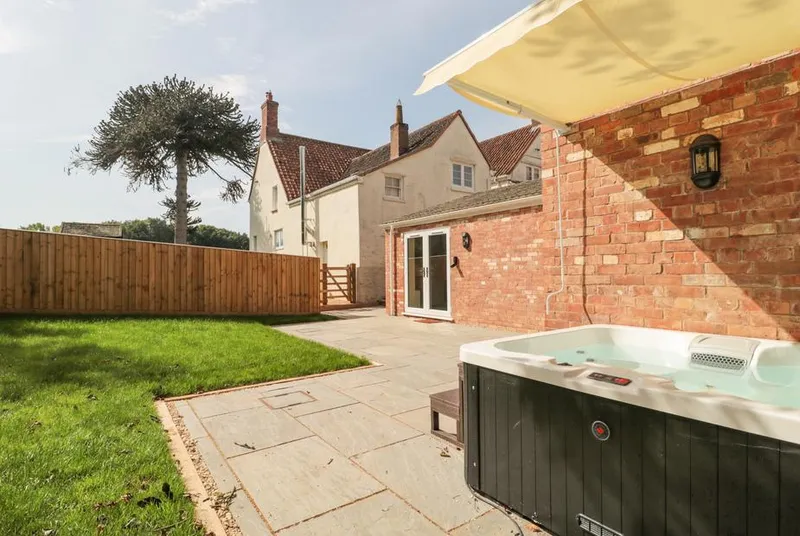 The Nest hot tub on patio with enclosed garden behind