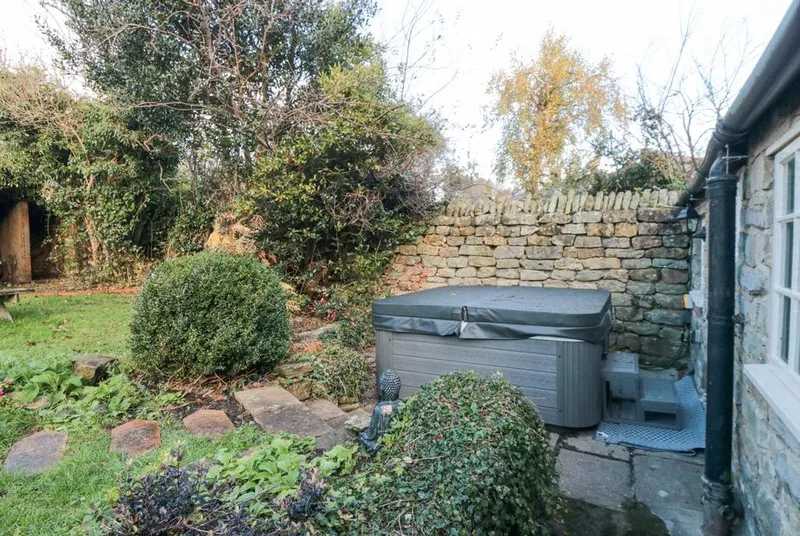 The Nook hot tub in sheltered garden corner with stone wall