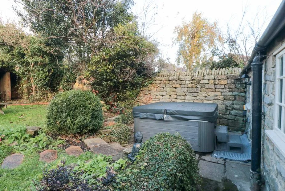 The Nook hot tub in sheltered garden corner with stone wall