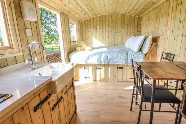 The Oak Hut interior with roll-top bath and bed