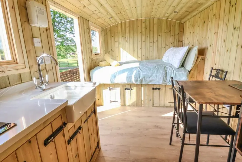 The Oak Hut interior with roll-top bath and bed