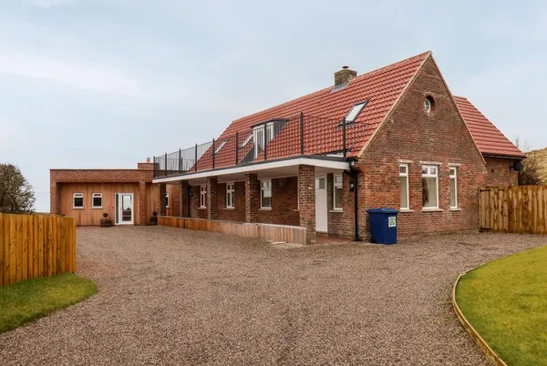 The Old Guard House full exterior showing scale and wraparound garden