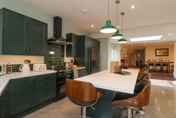 The Old Guard House kitchen and dining area with skylights and green cabinetry