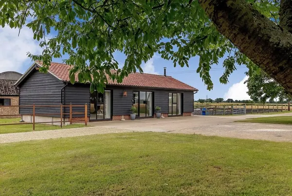 The Old Workshop black timber barn exterior with red tile roof