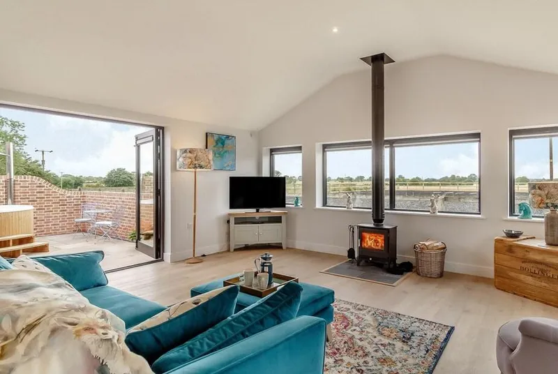 The Old Workshop open-plan living space with panoramic window and wood burner