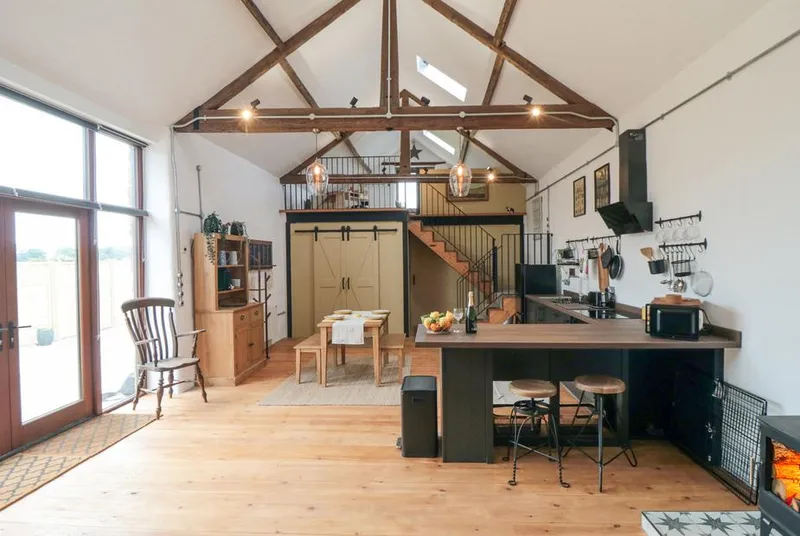 The Old Workshop open-plan barn interior with vaulted beams and mezzanine