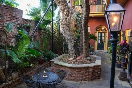 Courtyard with a large tree, brick planter, and patio seating