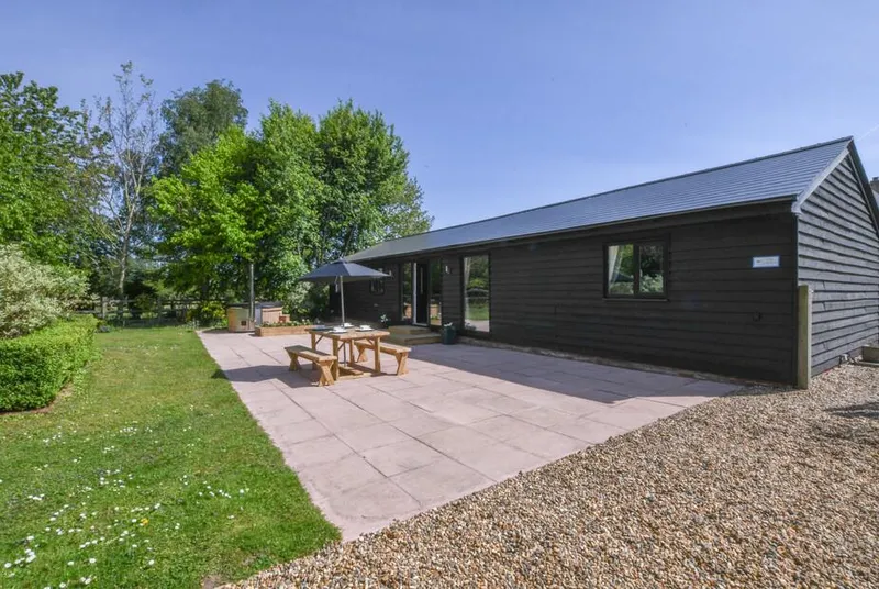 The Piglets black timber barn exterior with patio garden