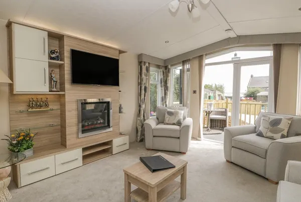 The Sequoia living room with fireplace, TV and patio doors to deck