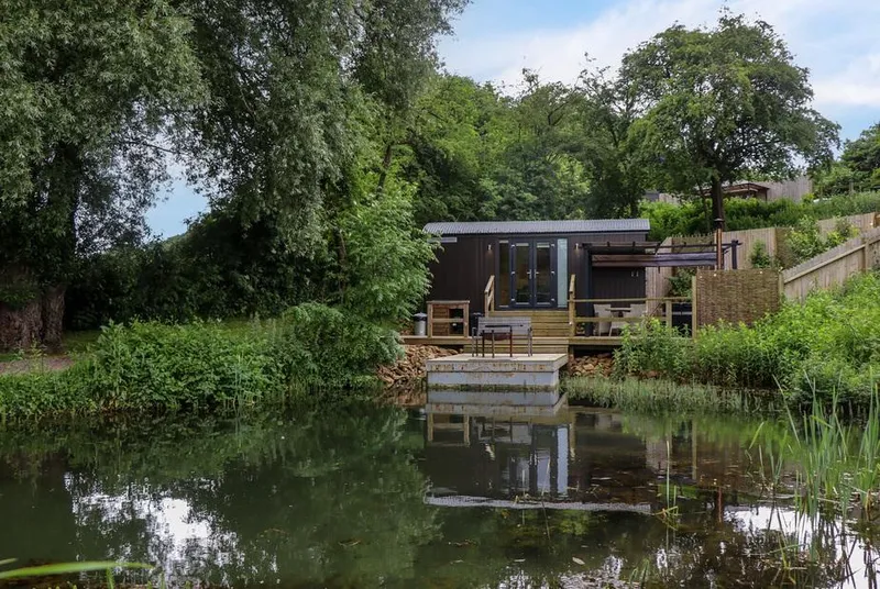 The Shepherds Hut at Bridge Lake Farm & Fishery across its private pond