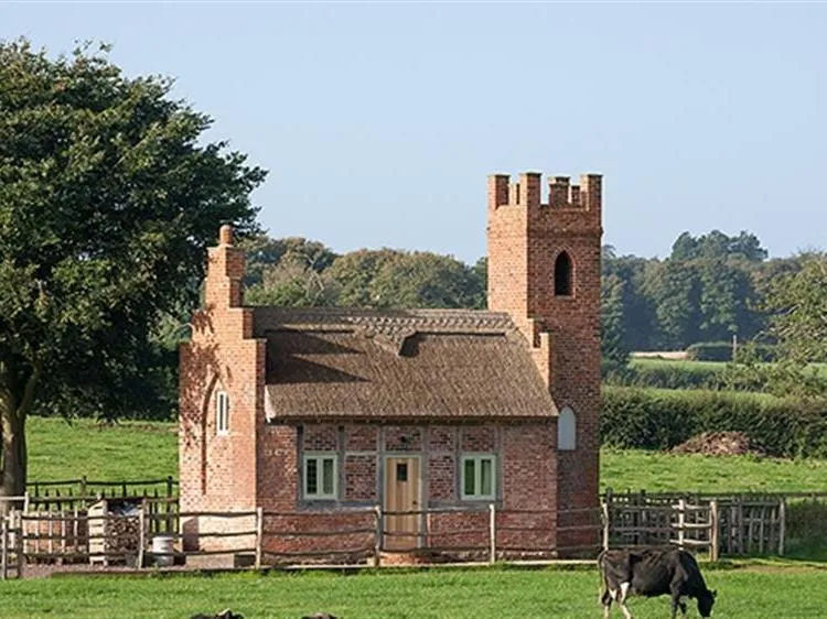The Shooting Folly brick tower and thatched exterior