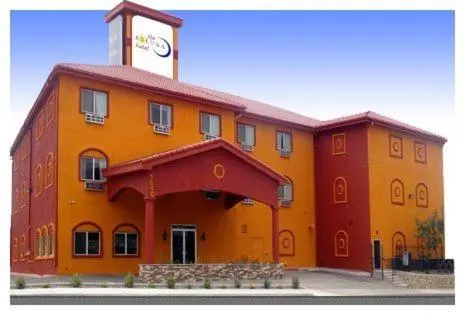 Orange and red hotel with a portico and a Soluna rooftop sign