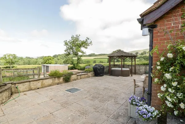The Stables wide patio with gazebo hot tub and countryside panorama