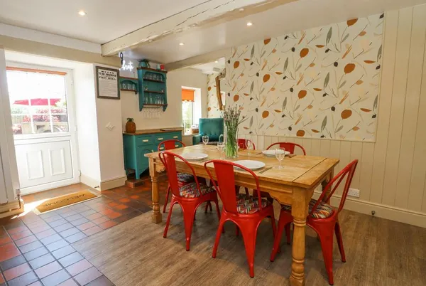 The Stone Masons House farmhouse kitchen with red chairs and botanical wallpaper