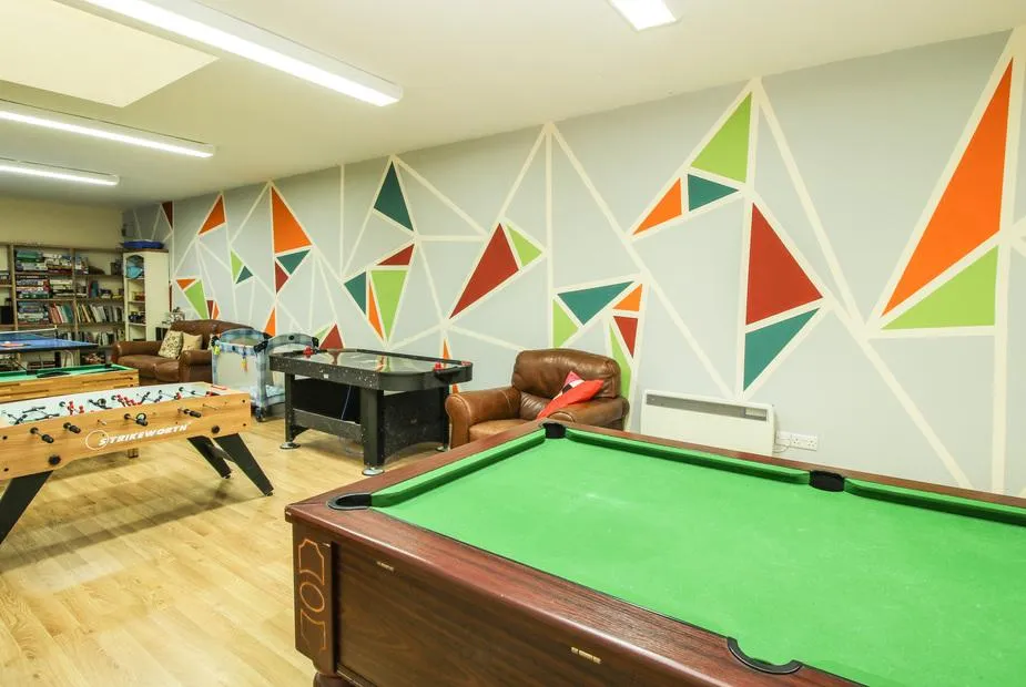 The Wain House games room with pool table and mural wall
