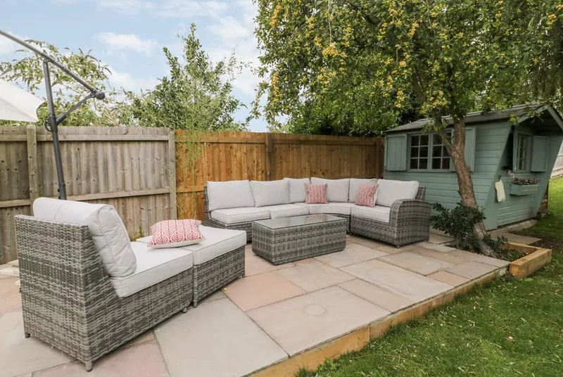The Willows garden seating terrace beneath mature trees