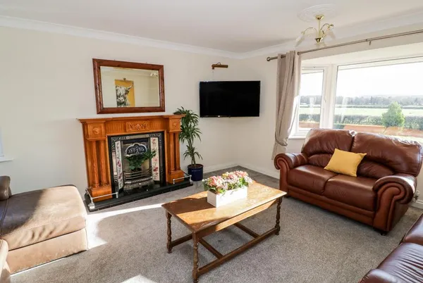 Tixall Manor Farm living room with fireplace and leather sofas