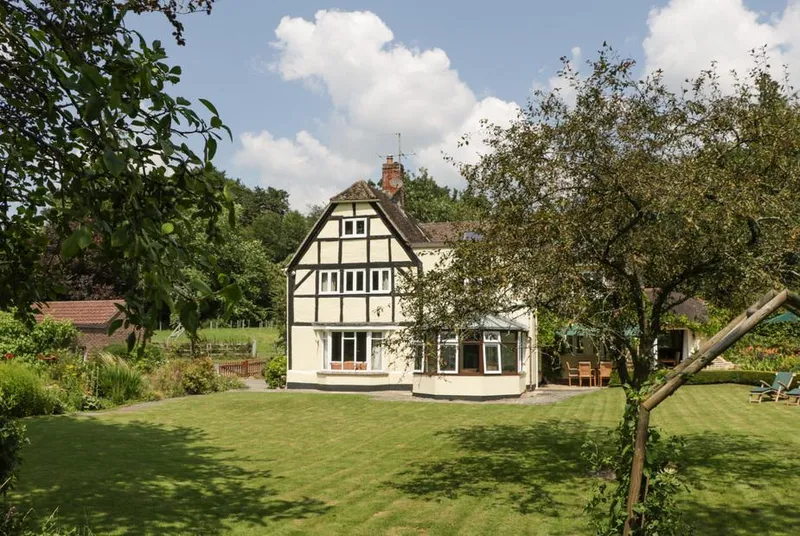 Valley House half-timbered facade from garden lawn on a sunny day