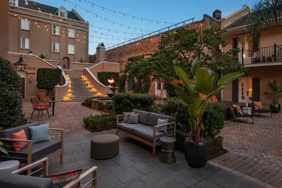 Courtyard seating under string lights with a lantern-lit staircase