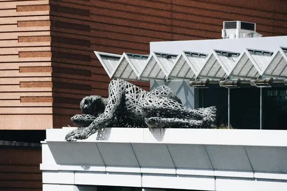 Statue of a woman laying on the side of a building