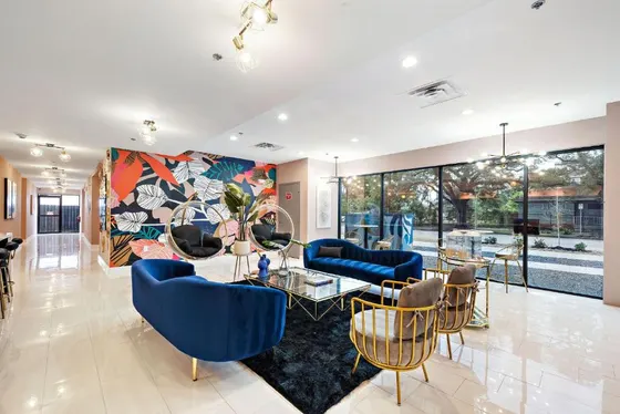 Lobby with blue velvet sofas and a colorful tropical mural