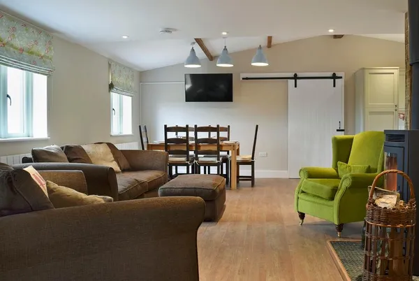 Waxwing Cottage open-plan lounge and dining space with stove