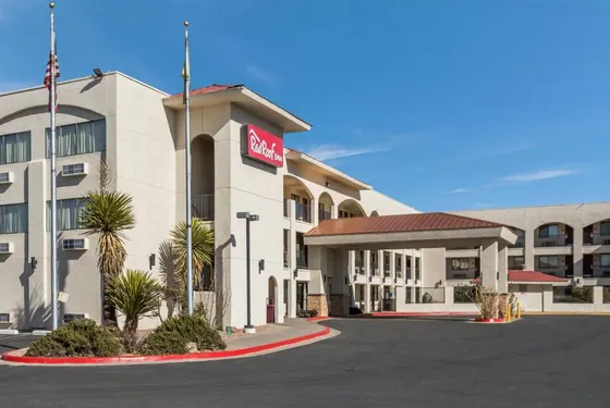Tan hotel with arched balconies and a Red Roof Inn sign