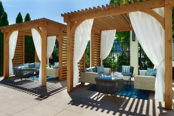 Wooden pergola with couches and chairs on a patio