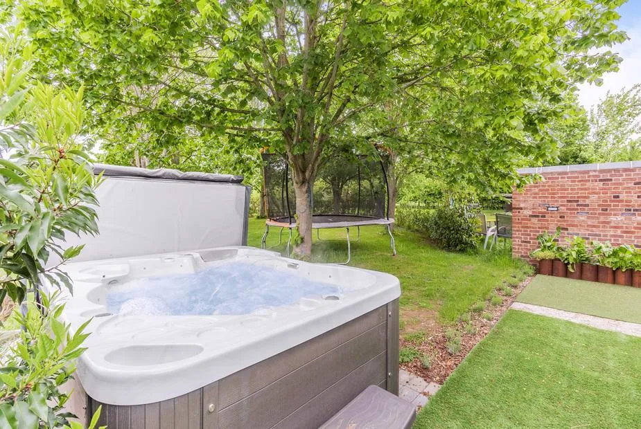 Willow Loft outdoor hot tub in lush green garden