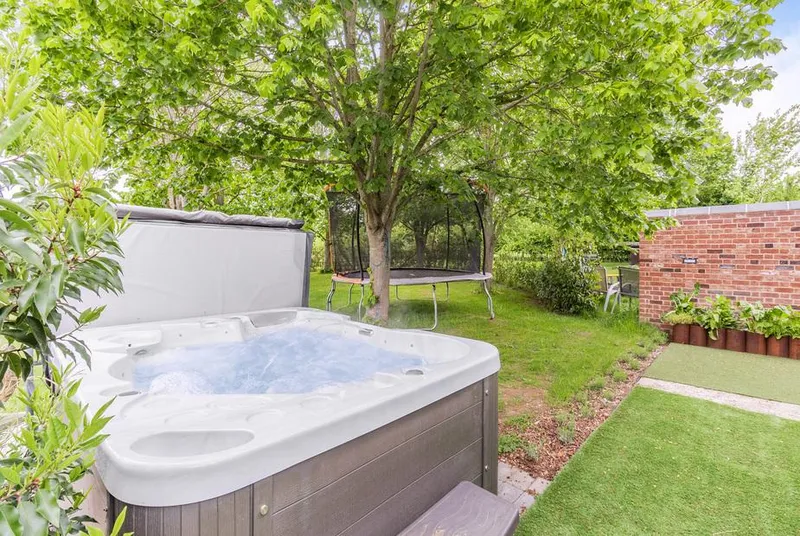 Willow Loft outdoor hot tub in lush green garden