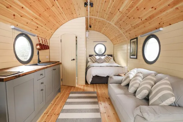 Willow Pod full interior with bed, sofa, kitchen and vaulted pine ceiling