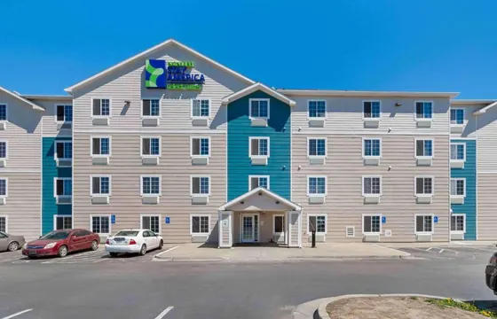 Large apartment building with cars parked in a parking lot