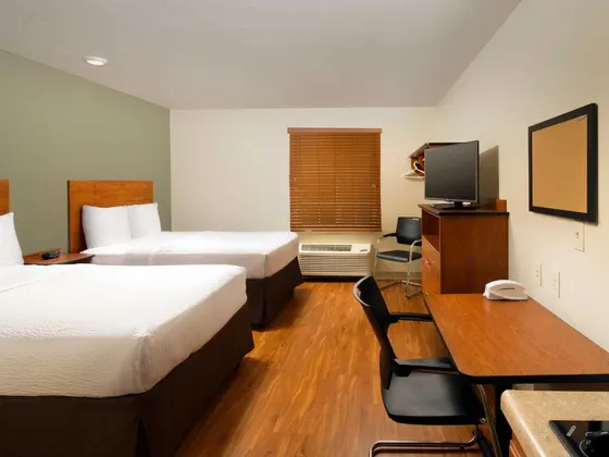 Two-bed room with a wooden desk and laminate floors