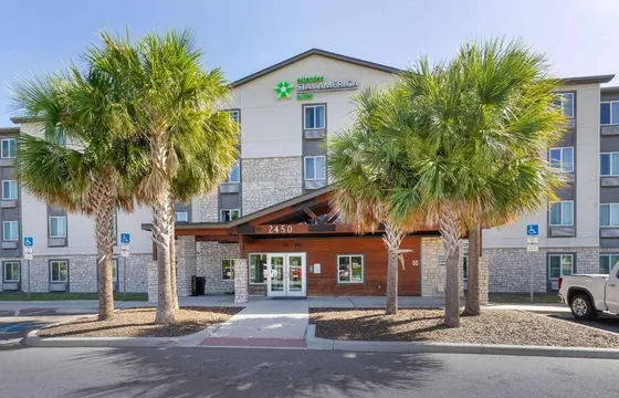 Hotel with two palm trees in front of it