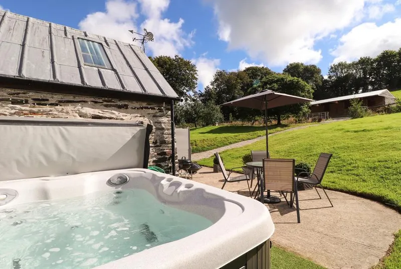 Y Felin at Coed Cadw hot tub beside the hillside patio
